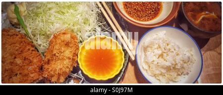 Pork tenderloin katsu meal with sticky rice and sesame sauce, sticky rice, green tea, miso soup, and cabbage Stock Photo
