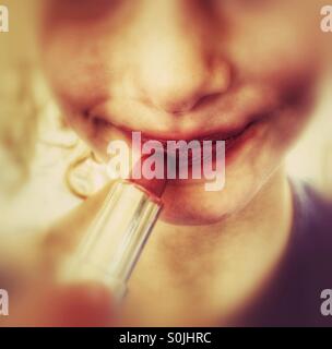 Young girl applying lipstick Stock Photo