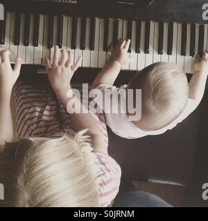 Photo  taken from the top of siblings learning,   playing piano together Stock Photo