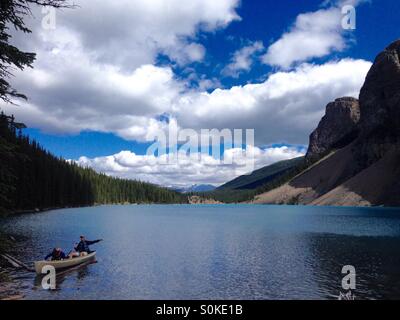 People in a canoe on a summer day floating on Moraine Lake in Alberta Canada Stock Photo