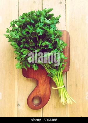 Big bunch of parsley on a wooden cutting board. Stock Photo