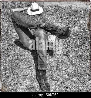 Man lying down with hat on face. Stock Photo