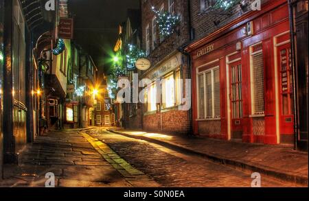 A medieval street in York called The Shambles at night. Lit by colourful artificial lights at night. Stock Photo