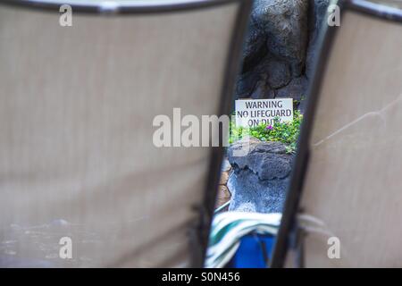 No life guard on duty sign between chairs. Stock Photo