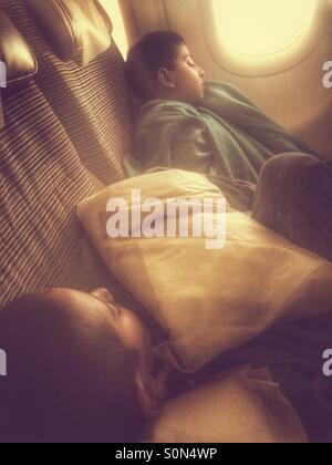 Two boys sleeping on airplane