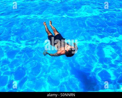 Man chilling in the swimming pool Stock Photo