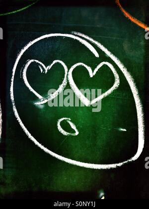 Analogue emoji drawn on a blackboard in school with chalk Stock Photo