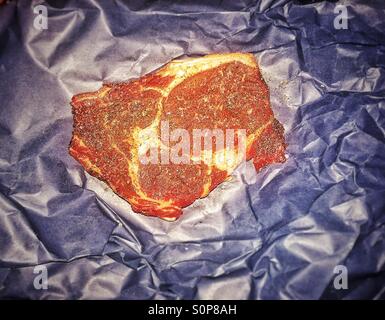 Grass fed ribeye Steak on paper Stock Photo