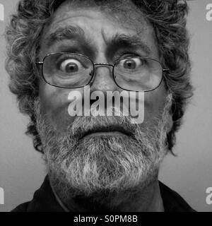 Man with glasses, age 64, with quizzical expression, black and white - model released Stock Photo