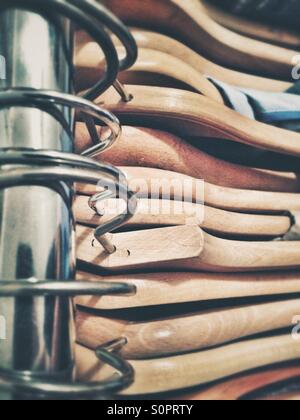 Wooden coat hangers on a hanging rail of a clothes rack Stock Photo