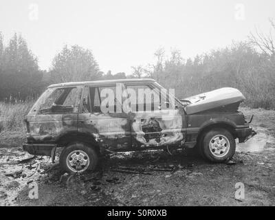 A burnt out Range Rover in rural Northumberland, UK. Stock Photo