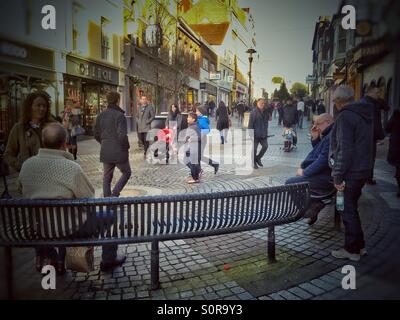 People sitting on benches in Peascod Street in Windsor, Berkshire. Stock Photo