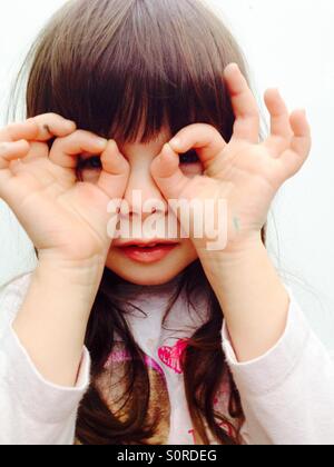 3-year old girl looking though her fingers Stock Photo