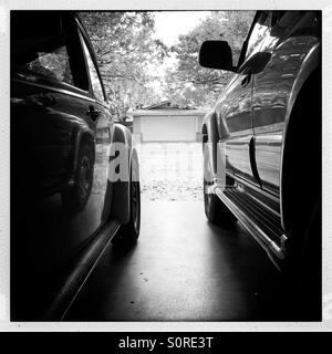 1974 VW Super Beetle parked in a garage with an SUV. Stock Photo