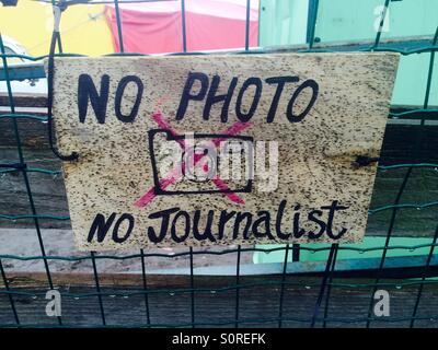 Sign on the Women and Children's centre in the Jungle refugee camp, Calais. The home made sign says 'No Photo, No Journalist' and shows a crude line drawing of a camera with a Red Cross through Stock Photo