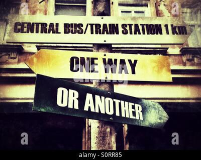 Wooden sign indicating One way or another and Central bus/train station Stock Photo