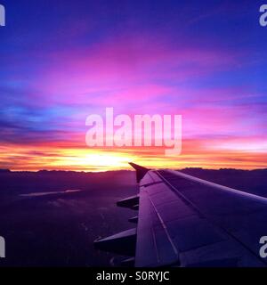 Beautiful sunrise at take off from Zurich, Switzerland, showing wing and mountains. Stock Photo