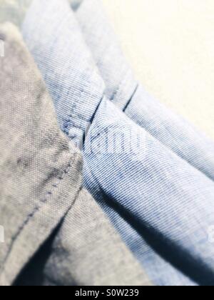 Blue and grey shirts on coathangers Stock Photo