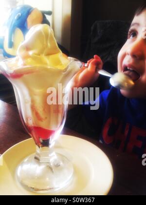 Young boy eating an ice cream sundae. Stock Photo