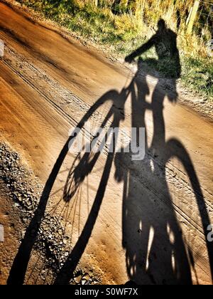 Mountain bike rider shadow Selfie on a dirt track Stock Photo