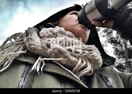 Woman drinking coffee on a rainy cold day Stock Photo