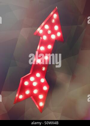 Brightly lit red arrow points up Stock Photo