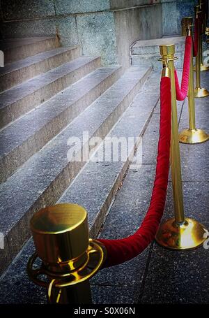 Velvet red ropes and stanchions keep an event exclusive Stock Photo