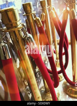 Red velvet ropes and brass stanchions signify exclusivity. Stock Photo