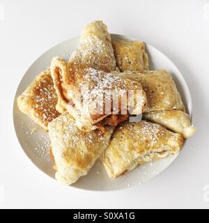 Freshly baked apple turnover pastries on a white plate. Stock Photo