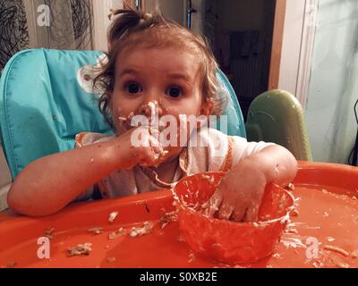 17 months baby eating by herself Stock Photo