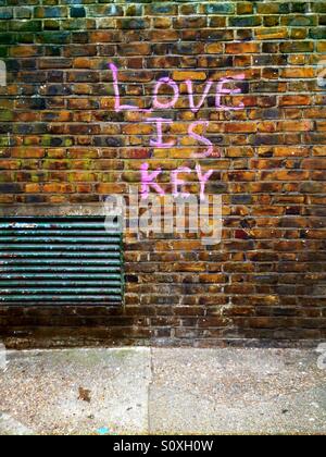 Love is key graffiti on a brick wall in Shoreditch near Brick Lane, London, England, UK