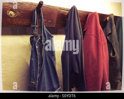 Hanging jackets and overalls. Hanging on wall mounted pegs Stock Photo