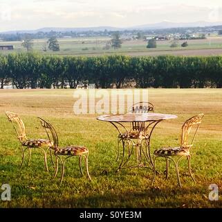 Deserted iron table and chairs with a high view of countryside in summertime Stock Photo