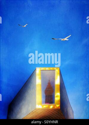 Blackpool Tower reflected in golden wedding chapel on Blackpool promenade with two seagulls flying past Stock Photo