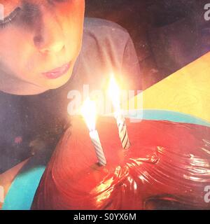 Boy blowing candles on his birthday chocolate cake Stock Photo