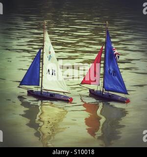 Traditional toy sailing boats on boating lake Stock Photo