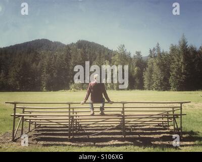 Man sitting on bleachers Stock Photo