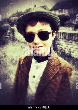 A young boy wearing a hat and sunglasses. Stock Photo