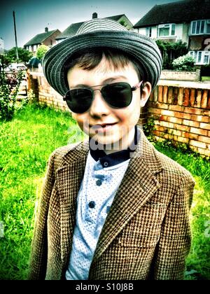 A young boy wearing a hat and sunglasses. Stock Photo