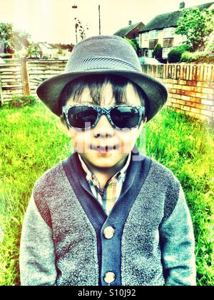 A young boy wearing a hat and sunglasses. Stock Photo