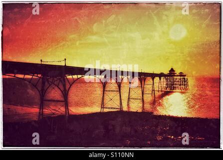 An Antique Grunge Effect Picture of the Sun Setting over Clevedon Pier in North Somerset, England. Clevedon Pier is the only visitable Grade One Listed Pier in England. Photo Credit - © COLIN HOSKINS. Stock Photo