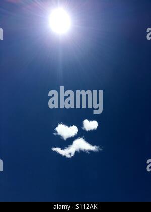 Clouds form a 'man in love' emoji, with heart-shaped eyes and a moustache Stock Photo