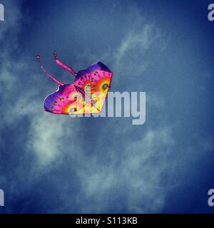 Colorful kite flying against a blue sky Stock Photo