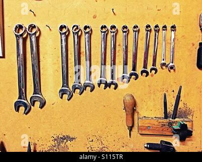 Spanners and work tools hanging on a wall Stock Photo
