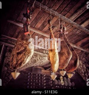 Legs of jamon ibetico hanging from ceiling in a tapas bar Stock Photo