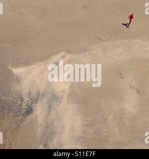 Boy running on beach in red shirt Stock Photo