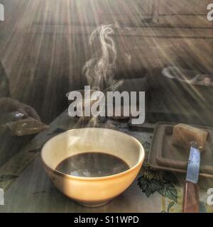 Bowl of hot coffee on breakfast table. Stock Photo
