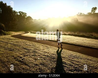 A man runs through the early morning light in Clifton Hill, Melbourne, Victoria, Australia Stock Photo