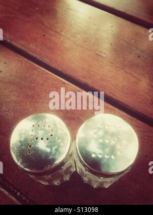 Salt and pepper shakers on a wooden surface Stock Photo