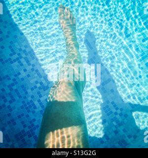 A ladies if in a swimming pool with shadows and bubbles. Stock Photo